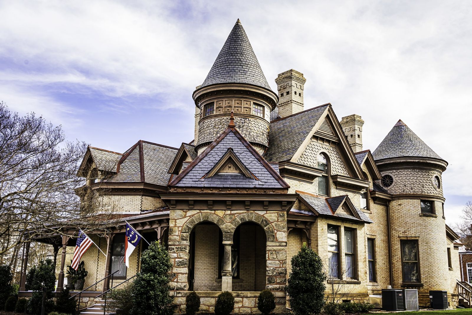 This Victorian features a variety of architectural elements including brick, stone, shingles, slate tiles, and turrets.